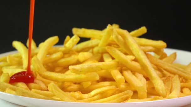 Pouring tomato sauce over french fries. Popular fast food, deep fried potato chips. Super slow motion video — ストック動画