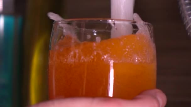 Gieten van water in oranje badschuim. 4k super slow-motion shot close-up — Stockvideo