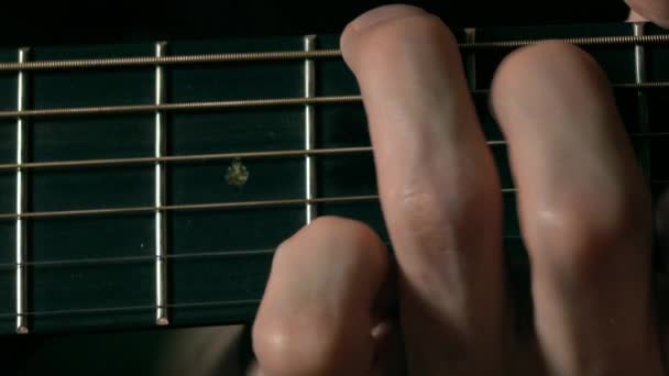 Guitarrista mano tocando cuerdas en diapasón. Actuación musical. Vídeo macro 4K — Vídeo de stock