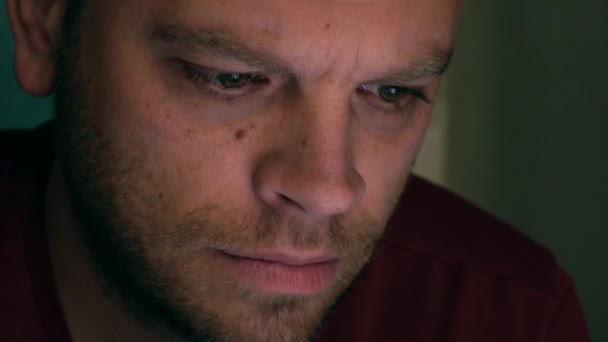 Portrait of focused bearded man using his tablet computer. Screen reflecting in the eyes, device lighting glow. 4K close up shot — Stock video