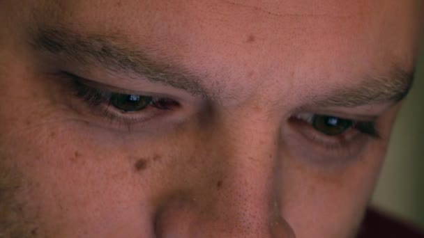 Oči vážného bělocha, který používá svůj tablet. Obrazovka se odráží v očích, zařízení svítí. 4K extrémní close up video — Stock video