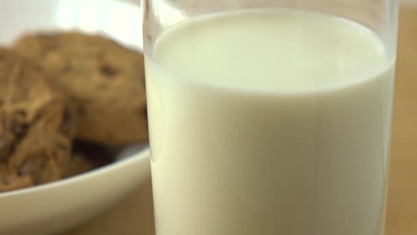 Печиво з шоколадними чіпсами та склянка молока на сніданок 4K крупним планом — стокове відео