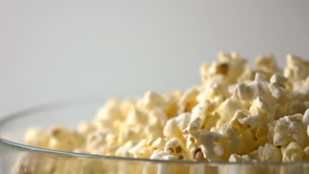 Mans hand håva popcorn från en glasskål. 4k närbild dolly skott — Stockvideo