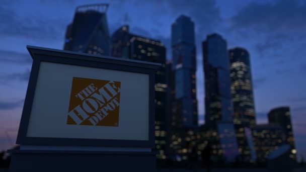 Cartelera con el logotipo de The Home Depot por la noche. Rascacielos distritos de negocios borrosa fondo. Clip editorial 4K — Vídeos de Stock