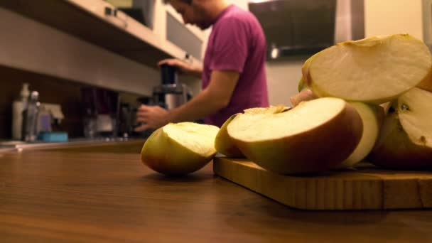 Hombre usando exprimidor en la cocina. Haciendo jugo de manzana en casa. 4k primer plano de vídeo — Vídeos de Stock