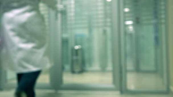 Travailleur de laboratoire déconcentré portant une robe blanche entrant dans le laboratoire clinique vidéo 4K — Video