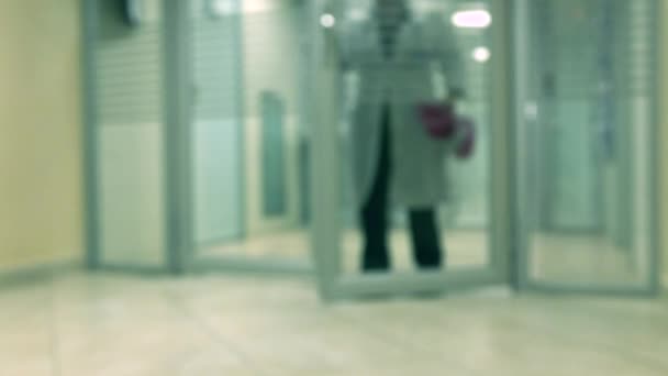 Blurred lab worker wearing white gown leaving hospital laboratory 4K video — Stock Video