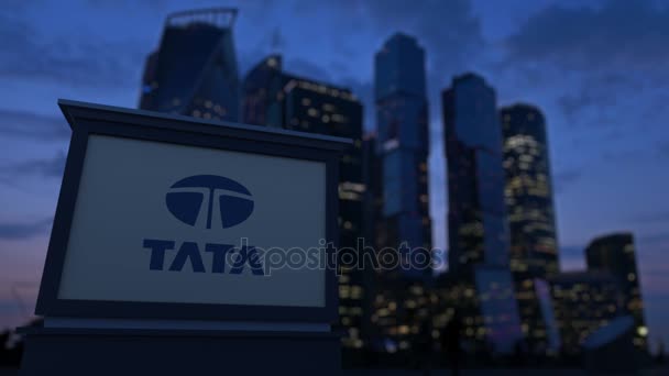 Panneau de signalisation avec logo Tata Group dans la soirée. Fond flou de gratte-ciel de quartier d'affaires. Clip éditorial 4K — Video