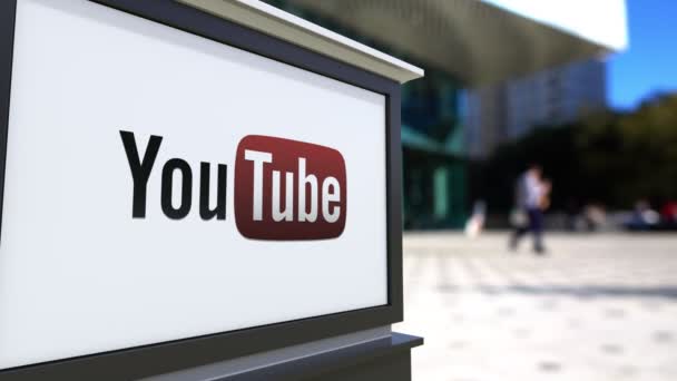 Pouliční nápisy deska s Youtube logo. Centrum rozmazané office a chodící lidé pozadí. Úvodník 4k 3d vykreslování — Stock video