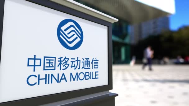 China Mobile logosu ile sokak Tabela Pano. Bulanık ofis Merkezi ve yürüyen insanlar arka plan. Editoryal 4k 3d render — Stok video