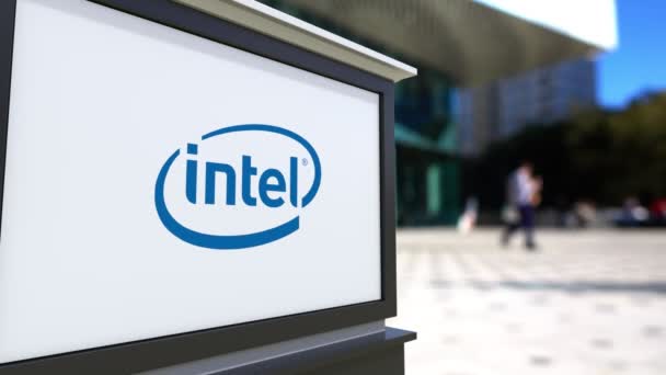 Уличная вывеска с логотипом корпорации Intel. Размытый офисный центр и ходячий фон. 4K 3D-рендеринг — стоковое видео