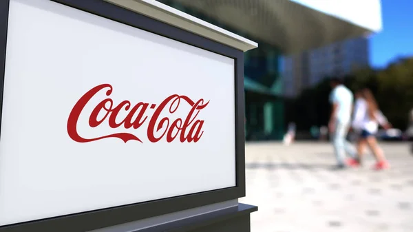 Papan nama jalan dengan logo Coca-Cola. Blurred kantor pusat dan berjalan orang latar belakang. Perenderan 3D Editorial — Stok Foto