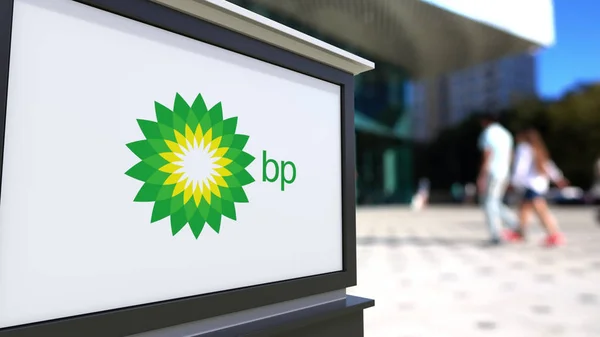 Street signage board with BP logo. Blurred office center and walking people background. Editorial 3D rendering — Stock Photo, Image