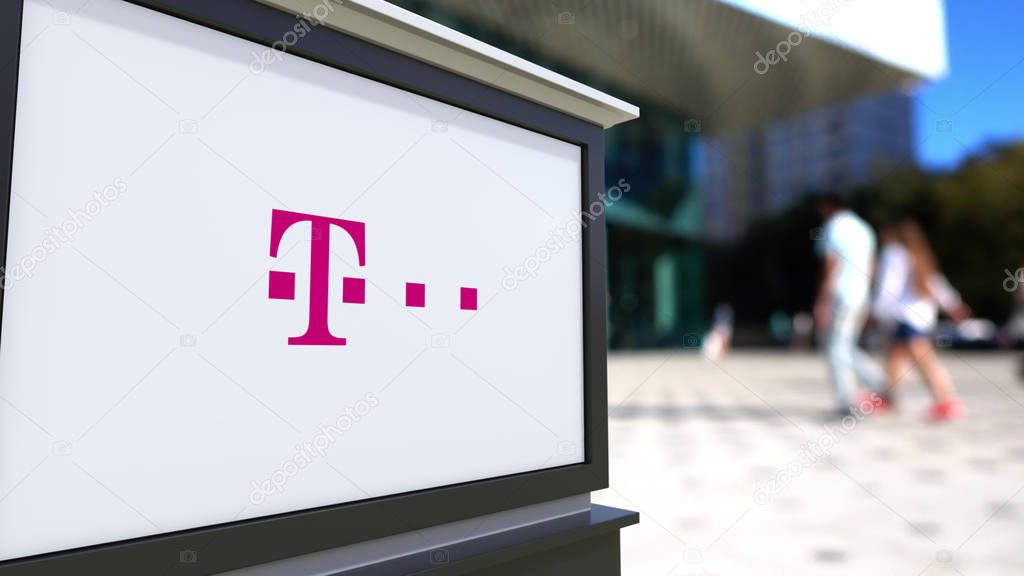 Street signage board with T-Mobile logo. Blurred office center and walking people background. Editorial 3D rendering United States