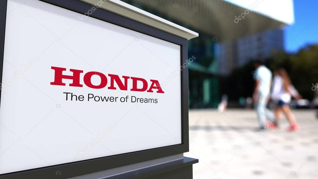 Street signage board with Honda logo. Blurred office center and walking people background. Editorial 3D rendering United States