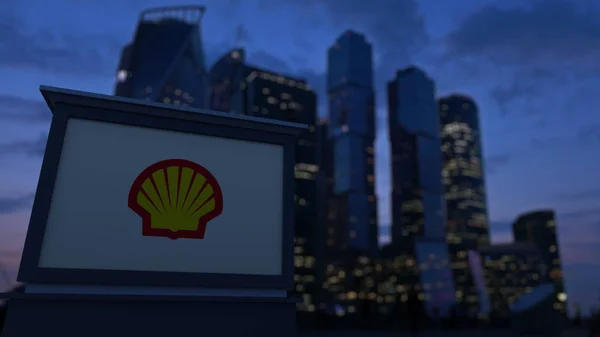 Straßenschildertafel mit Shell Oil Company Logo am Abend. verschwommen Geschäftsviertel Wolkenkratzer Hintergrund. redaktionelles 3D-Rendering — Stockfoto