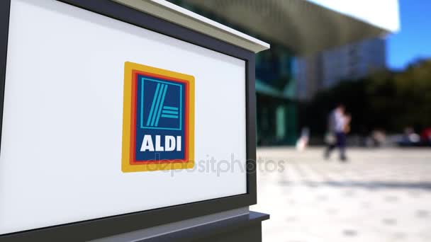 Gatan skyltar ombord med Aldi logotyp. Suddig office center och vandrande folk bakgrund. Redaktionella 4k 3d-rendering — Stockvideo