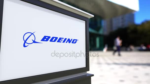 Placa de sinalização de rua com logotipo da Boeing Company. Centro de escritórios desfocado e pessoas ambulantes fundo. Editorial 4K 3D renderização — Vídeo de Stock