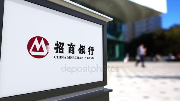 Cartelera con el logotipo del Banco de Comerciantes de China. Centro de oficina borrosa y gente caminando fondo. Representación editorial 4K 3D — Vídeo de stock