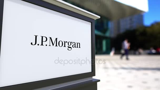 Cartelera con el logotipo de J.P. Morgan. Centro de oficina borrosa y gente caminando fondo. Representación editorial 4K 3D — Vídeo de stock