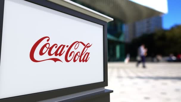 Coca Cola logosu ile sokak Tabela Pano. Bulanık ofis Merkezi ve yürüyen insanlar arka plan. Editoryal 4k 3d render — Stok video