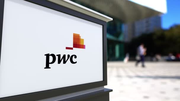 Cartelera con el logotipo de PricewaterhouseCoopers PwC. Centro de oficina borrosa y gente caminando fondo. Representación editorial 4K 3D — Vídeo de stock