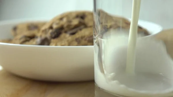 Chocolate chip cookies och mjölk som hälls i ett glas — Stockfoto