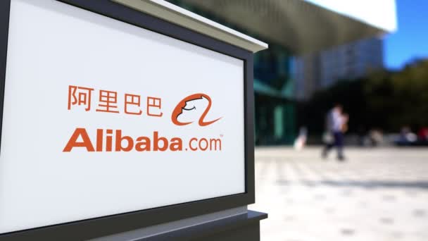 Cartelera con el logotipo de Alibaba.com. Centro de oficina borrosa y gente caminando fondo. Representación editorial 4K 3D — Vídeo de stock