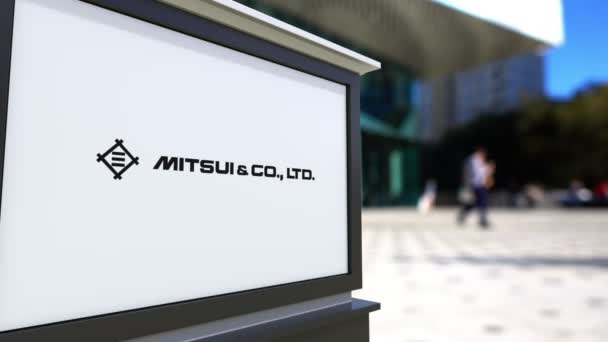 Cartelera con logotipo de Mitsui y compañía. Centro de oficina borrosa y gente caminando fondo. Representación editorial 4K 3D — Vídeo de stock