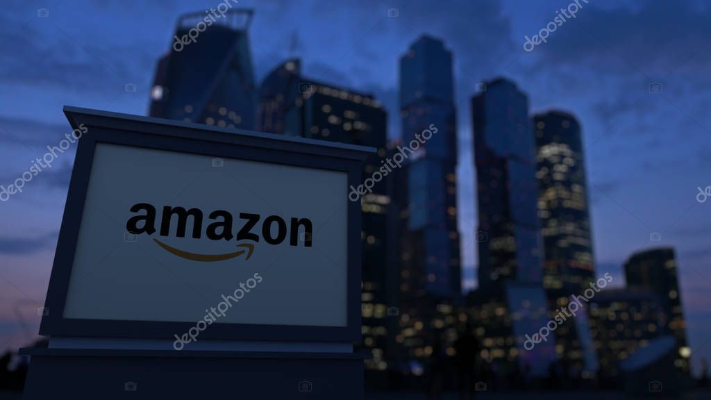 Street signage board with Amazon.com logo in the evening. Blurred business district skyscrapers background. Editorial 4K clip, ProRes