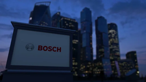 Tablero de señalización con el logotipo de Robert Bosch GmbH por la noche. Rascacielos distritos de negocios borrosa fondo. Representación Editorial 3D — Foto de Stock