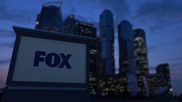 Street signage board with Fox Broadcasting Company logo in the evening. Blurred business district skyscrapers background. Editorial 3D rendering — Stock Photo, Image