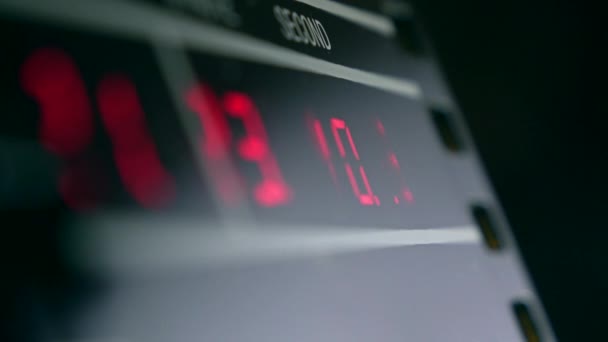 赤い光る数字で暗い部屋で電子時計。正確な時間計測とデジタルの概念。4 k ビデオ — ストック動画