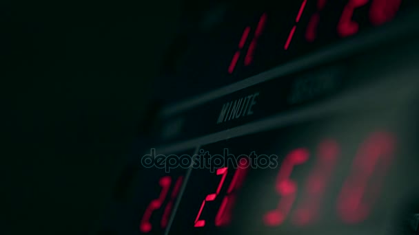 Digital clock in dark room with red glowing digits. Time measurement and electronic technology concepts. 4K video — Stock Video