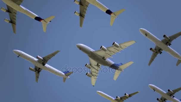 Aviones comerciales modernos volando contra el cielo azul. Viajes, contaminación atmosférica o conceptos de inmigración. Animación de bucle sin costura 4K — Vídeo de stock