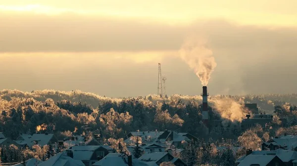 Vereiste Bäume, verschneite Dächer und rauchende Pfeife bei Sonnenuntergang — Stockfoto