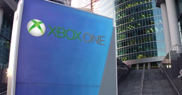 Placa de sinalização de rua com logotipo Xbox One. Escritório moderno centro arranha-céus e escadas de fundo. Editorial 4K 3D renderização — Vídeo de Stock