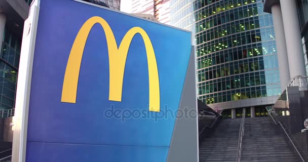 Уличная вывеска с логотипом МакДональдса. Современный офисный центр небоскреб и лестница фон. 4K 3D-рендеринг — стоковое видео