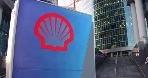 Cartelera con el logotipo de Shell Oil Company. Rascacielos moderno centro de oficina y escaleras de fondo. Representación editorial 4K 3D — Vídeo de stock