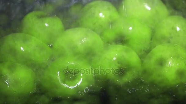 Несколько зеленых яблок были вымыты супер замедленной съемки — стоковое видео