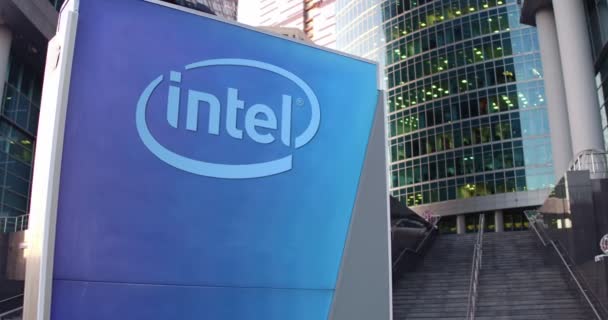 Уличная вывеска с логотипом корпорации Intel. Современный офисный центр небоскреб и лестница фон. 4K 3D-рендеринг — стоковое видео