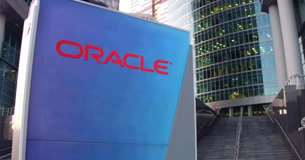 Placa de sinalização de rua com logotipo da Oracle Corporation. Escritório moderno centro arranha-céus e escadas de fundo. Editorial 4K 3D renderização — Vídeo de Stock