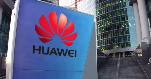Placa de sinalização de rua com logotipo da Huawei. Escritório moderno centro arranha-céus e escadas de fundo. Editorial 4K 3D renderização — Vídeo de Stock