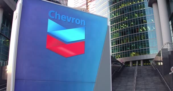 Straßenschildertafel mit Chevron Corporate Logo. modernes Bürozentrum Wolkenkratzer und Treppe Hintergrund. Editorial 4k 3D Rendering — Stockvideo