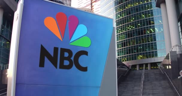 街道标牌板与国家广播公司Nbc的标志。现代办公中心摩天大楼和楼梯背景。编辑 4k 3d 渲染 — 图库视频影像