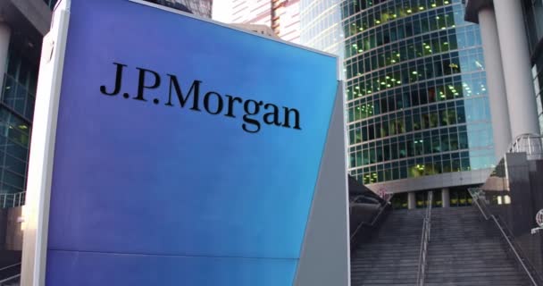 Уличная вывеска с логотипом J.P. Morgan. Современный офисный центр небоскреб и лестница фон. 4K 3D-рендеринг — стоковое видео