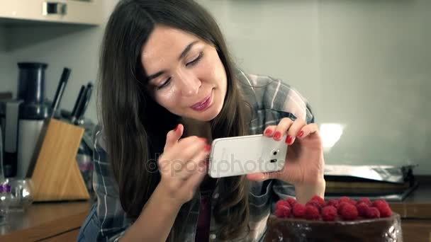 Hermosa joven morena haciendo fotos de su pastel recién cocinado. Cocina amateur y concepto de redes sociales. Steadicam 4K video — Vídeos de Stock