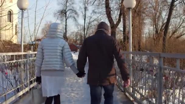 Paar, das Händchen haltend auf einer kleinen Brücke in der Nähe der Kathedrale geht. 4k Steadicam-Video — Stockvideo