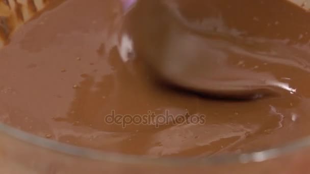 Mexendo chocolate derretido em uma tigela de vidro fechar 4K tiro — Vídeo de Stock