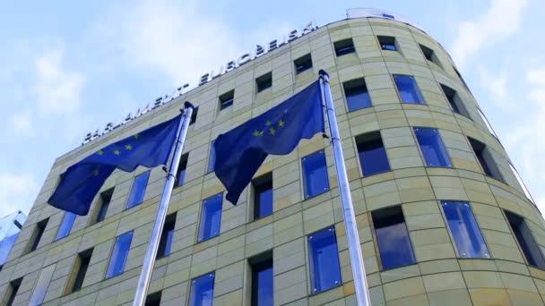 Gabinete do Parlamento Europeu em Varsóvia e agitando bandeiras da UE 4K tiro de ângulo baixo — Vídeo de Stock